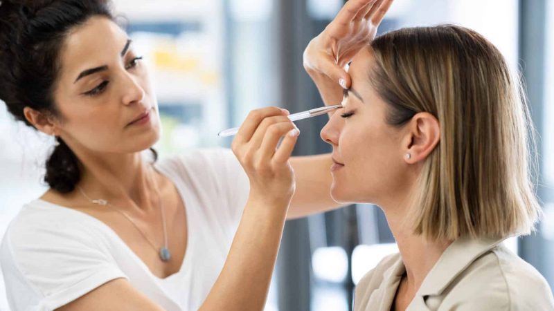 Arab makeup artist making up a woman in a beauty center. Beauty and Aesthetic concepts.