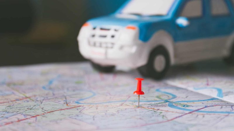 Toy car and push pin on the map. Travelling concept. Shallow depth of field.